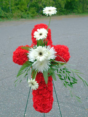 Cross with red carns, white gerbs.